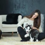 Woman snuggles with her husky puppy. Create a dog-friendly home.