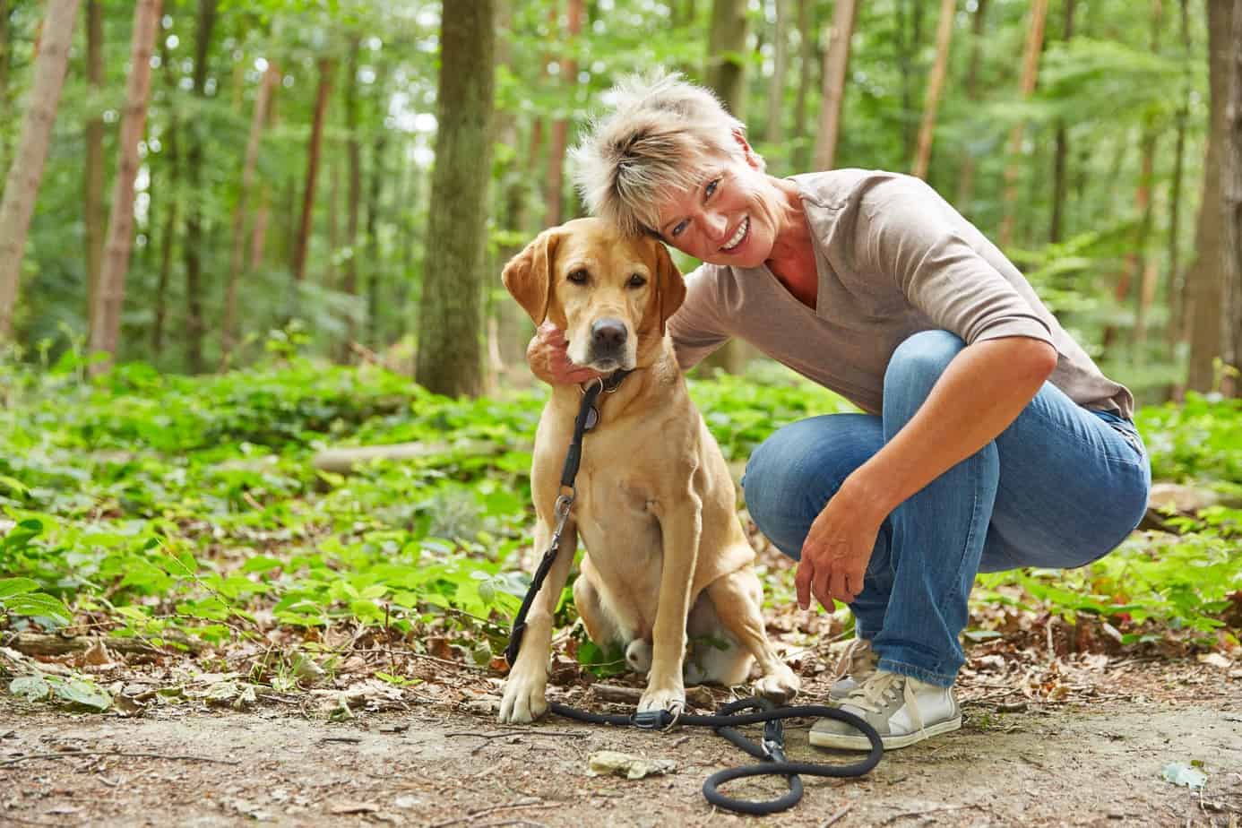 Woman cuddles with golden retriever. Seniors face dangers walking dogs.