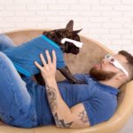 Man plays with French Bulldog. Image for Dog Fun Category page.