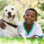 Little boy snuggles with Labrador Retriever. Another benefit of owning a pet is that your child learns to act politely and be more friendly to people.