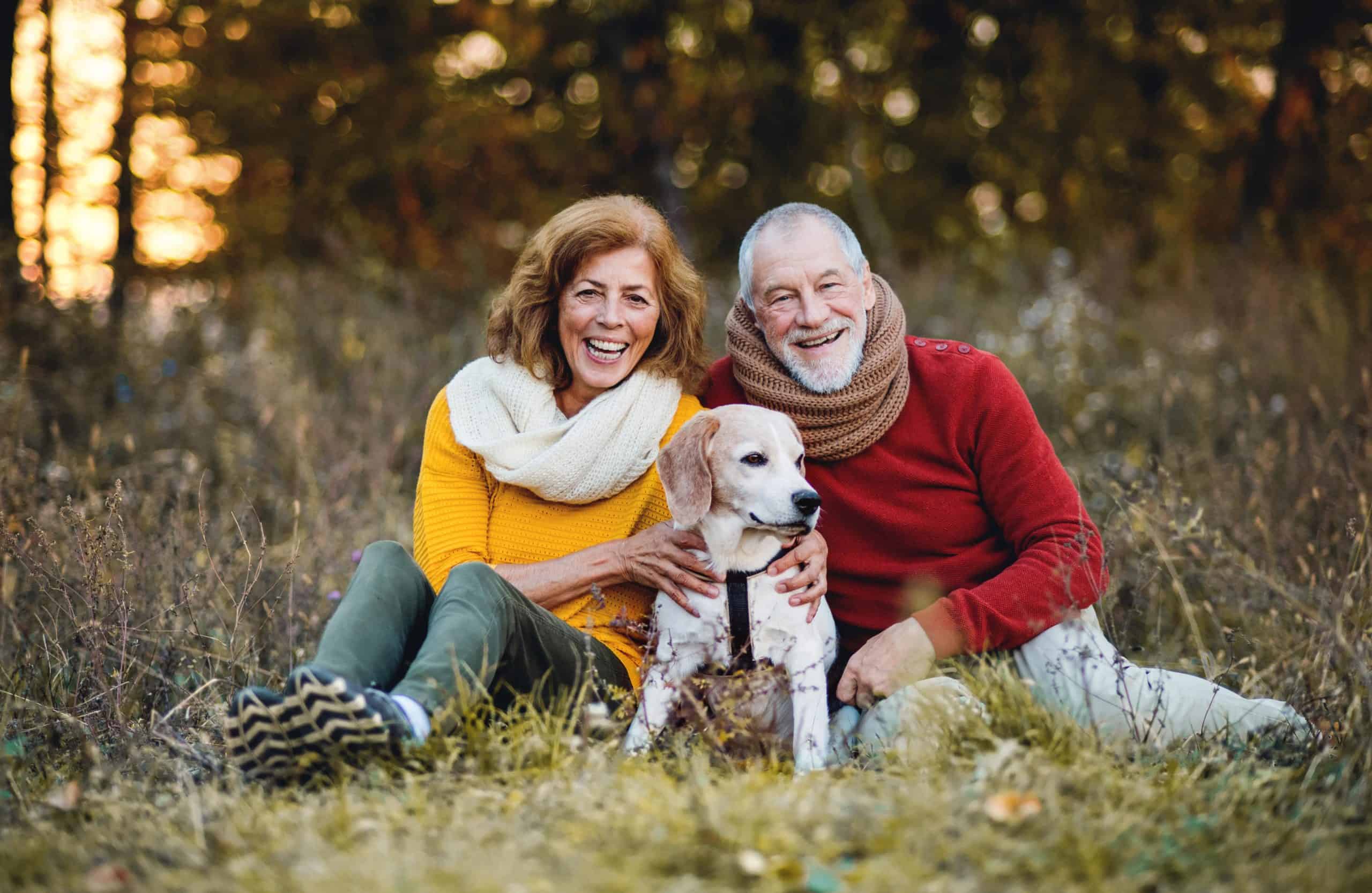 Older couple poses with their beagle. The easiest way to meet other dog lovers is to do everything you can with your dog.