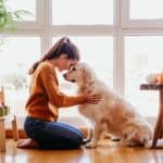 Woman cuddles with Golden Retriever. As a new dog owner, it's key to meet your dog's basic needs, including veterinary care, food, water, shelter, and toys.