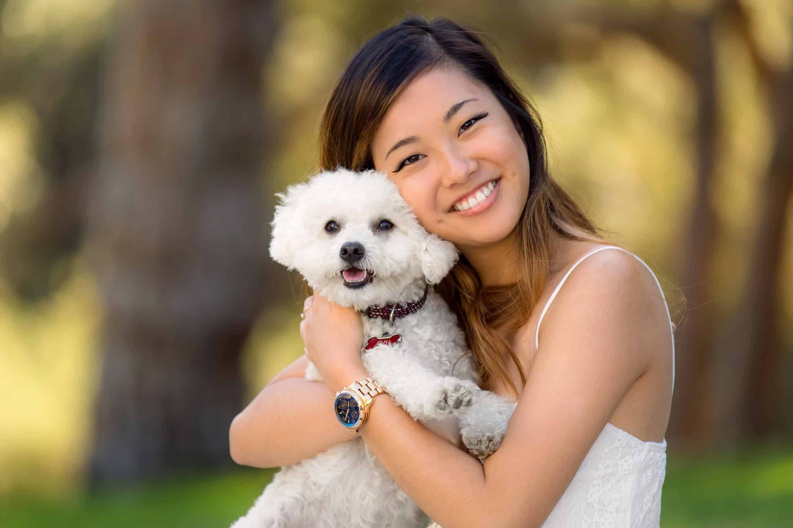 Woman hugs Bolognese puppy. Show your dog affection by using a gentle touch, providing favorite treats, and creating a safe space for your dog.