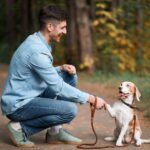 Man with beagle. Use DogsBestLife's dog training 101 expert tips, advice, and proven techniques.